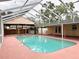 Screened-in pool and patio with an outdoor kitchen creating a relaxing and fun space at 2523 Krueger Lane, Tampa, FL 33618