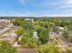 Aerial view of a neighborhood dotted with mature trees under a blue sky with sparse clouds at 2808 N Highland Ave, Tampa, FL 33602