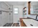 Bathroom featuring a tiled shower, a wooden countertop with a basin sink, and floating wooden shelves at 2808 N Highland Ave, Tampa, FL 33602