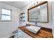 Bathroom featuring a stained wooden countertop with a white basin sink, as well as floating wooden shelves at 2808 N Highland Ave, Tampa, FL 33602