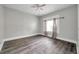 A minimalist bedroom with light grey walls, dark grey flooring, and a bright window dressed with a set of neutral curtains at 2808 N Highland Ave, Tampa, FL 33602