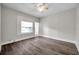 Bedroom featuring dark grey flooring, light grey walls, a ceiling fan, and a bright window dressed with blinds at 2808 N Highland Ave, Tampa, FL 33602