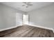 Bedroom featuring dark grey flooring, light grey walls, a ceiling fan, and a view into another room at 2808 N Highland Ave, Tampa, FL 33602