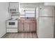 Cozy kitchen with white appliances and light pink cabinets providing ample storage space at 2808 N Highland Ave, Tampa, FL 33602