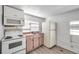 Bright kitchen featuring white appliances, wood flooring, and window bringing in natural light at 2808 N Highland Ave, Tampa, FL 33602