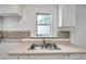 Close up of Kitchen double sink, white cabinets, and modern backsplash at 2808 N Highland Ave, Tampa, FL 33602