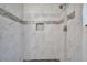Shower featuring white marble-like tiling with a black pebbled shower floor at 2808 N Highland Ave, Tampa, FL 33602