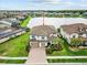Aerial view of a well-maintained home showcasing the tile roof, landscaping, and waterfront location at 28565 Picana Ln, Wesley Chapel, FL 33543