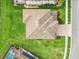 An aerial view of tile roof, large backyard, lush landscaping, and neighborhood streets at 28565 Picana Ln, Wesley Chapel, FL 33543