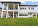 Modern two-story home with balcony and patio overlooking a spacious, well-manicured green lawn at 28565 Picana Ln, Wesley Chapel, FL 33543