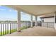 Covered balcony featuring elegant white columns and views of the picturesque lake at 28565 Picana Ln, Wesley Chapel, FL 33543