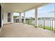 Covered balcony with black metal railing overlooking the pristine lake views and lush greenery at 28565 Picana Ln, Wesley Chapel, FL 33543