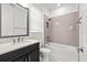 Stylish bathroom featuring a tiled shower-tub combo, dark vanity, and a large mirror at 28565 Picana Ln, Wesley Chapel, FL 33543