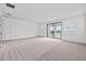 Spacious bedroom featuring neutral carpet, ample natural light, and sliding glass door to balcony at 28565 Picana Ln, Wesley Chapel, FL 33543