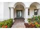 Elegant entryway with arched columns, glass front doors and beautiful landscaping at 28565 Picana Ln, Wesley Chapel, FL 33543