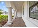 Arched columns provide covered walkway with tiled floor to front door at 28565 Picana Ln, Wesley Chapel, FL 33543