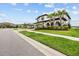 Charming home featuring a paver driveway, tile roof, arched columns and landscaped front yard at 28565 Picana Ln, Wesley Chapel, FL 33543