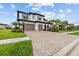 Beautiful home featuring a paver driveway, two-car garage, basketball hoop, and lush landscaping at 28565 Picana Ln, Wesley Chapel, FL 33543