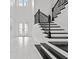 Grand foyer with marble flooring, decorative front door, and black iron staircase at 28565 Picana Ln, Wesley Chapel, FL 33543