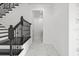Well-lit hallway with black staircase and marble floors, creating an elegant transition between spaces at 28565 Picana Ln, Wesley Chapel, FL 33543