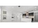 A modern, open-concept kitchen featuring dark cabinets, marble floors, and a white island at 28565 Picana Ln, Wesley Chapel, FL 33543