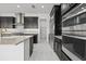 Modern kitchen featuring stainless steel appliances, sleek black cabinetry, and marble floors at 28565 Picana Ln, Wesley Chapel, FL 33543