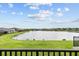 Picturesque lake view from covered balcony with lush green surroundings and beautiful clear skies at 28565 Picana Ln, Wesley Chapel, FL 33543