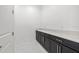 Elegant laundry room with dark cabinets, granite countertop, and modern finishes at 28565 Picana Ln, Wesley Chapel, FL 33543