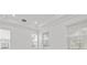 Bright and airy living area with tray ceiling detail, large windows and crisp white walls at 28565 Picana Ln, Wesley Chapel, FL 33543