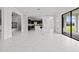 Open living space with fireplace, tile flooring and gourmet kitchen in the background at 28565 Picana Ln, Wesley Chapel, FL 33543