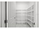 Walk-in pantry with ample shelving for organized storage and marble flooring at 28565 Picana Ln, Wesley Chapel, FL 33543