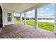 Covered patio with brick pavers offering scenic views of the backyard and lake at 28565 Picana Ln, Wesley Chapel, FL 33543