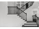 Elegant staircase with black iron railings and contrasting black and white accents at 28565 Picana Ln, Wesley Chapel, FL 33543