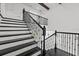 Elegant staircase with black and white design, and stylish railing details at 28565 Picana Ln, Wesley Chapel, FL 33543