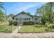 Quaint bungalow with a screened front porch and a green, fenced front lawn at 3008 E Wilder Ave, Tampa, FL 33610