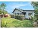 Cute home featuring an enclosed porch, tidy landscaping, and a partial lawn view at 3008 E Wilder Ave, Tampa, FL 33610