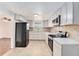 Updated kitchen featuring white cabinets, modern appliances, and stylish backsplash at 3008 E Wilder Ave, Tampa, FL 33610