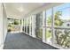 Covered front porch with screened windows, gray carpet, and view of the front yard at 3008 E Wilder Ave, Tampa, FL 33610