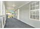 Enclosed front porch featuring screened windows, neutral carpet, and access to the home at 3008 E Wilder Ave, Tampa, FL 33610