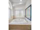 Bathroom featuring a garden tub, tiled surround, and picture window at 3089 Ashland Ter, Clearwater, FL 33761