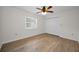 Bright bedroom with hardwood floors, a ceiling fan, a closet, and a window at 3089 Ashland Ter, Clearwater, FL 33761