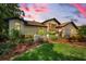 Beautiful exterior elevation view of home with manicured lawn, colorful plants, and a three car garage at 3089 Ashland Ter, Clearwater, FL 33761