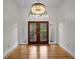 Elegant foyer featuring hardwood floors, a decorative chandelier, and a stylish front door at 3089 Ashland Ter, Clearwater, FL 33761