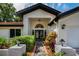 Elegant front entrance featuring a stylish door, manicured landscaping, and welcoming outdoor lighting at 3089 Ashland Ter, Clearwater, FL 33761