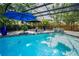 Beautiful pool area featuring a waterfall feature, poolside gazebo, and colorful landscaping at 3089 Ashland Ter, Clearwater, FL 33761