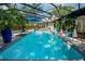 Beautiful screened pool area with ample deck space, lush landscaping, and a clear blue swimming pool at 3089 Ashland Ter, Clearwater, FL 33761