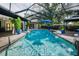 Inviting screened-in pool with clear blue water, poolside seating, and lush landscaping at 3089 Ashland Ter, Clearwater, FL 33761