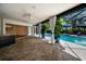 Covered patio area overlooking pool, with lush plants, ceiling fans, and connection to home's interior at 3089 Ashland Ter, Clearwater, FL 33761