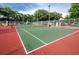 Bright community tennis court with playground in background and green and red surface at 3089 Ashland Ter, Clearwater, FL 33761