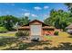 The barn is a large, brown building with a silver garage door and a pitched roof at 309 Hidden Lake Dr, Brandon, FL 33511